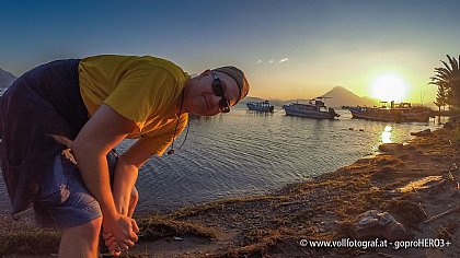 Manfred Scheucher vor einem See mit Vulkan im Hintergrund