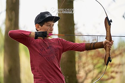 Junge schießt spannt den Bogen